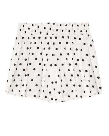 The Smocked Sleep Short by THE GREAT. PS25 SLEEP in Cream Polka Dot features an elastic waistband and a scattered black dot pattern on smooth loungewear fabric.