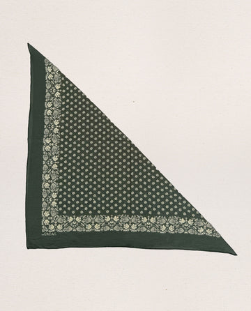 The Bandana – Small in Army Green, from THE GREAT. SP24 D2, is a meticulously crafted piece made from 100% cotton. This green triangular bandana showcases an intricate white floral and geometric design along its borders and inner area. Set against a plain background, it embodies the charm of vintage handkerchiefs while delivering an ultra-soft feel.