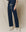 A person wearing The Wide Leg Cropped Sweatpant in True Navy, by THE GREAT. FALL 23 KNITS, features a drawstring waist and wide cropped legs, perfectly paired with white high-top sneakers. These 100% cotton pants offer stylish comfort and easy elegance.